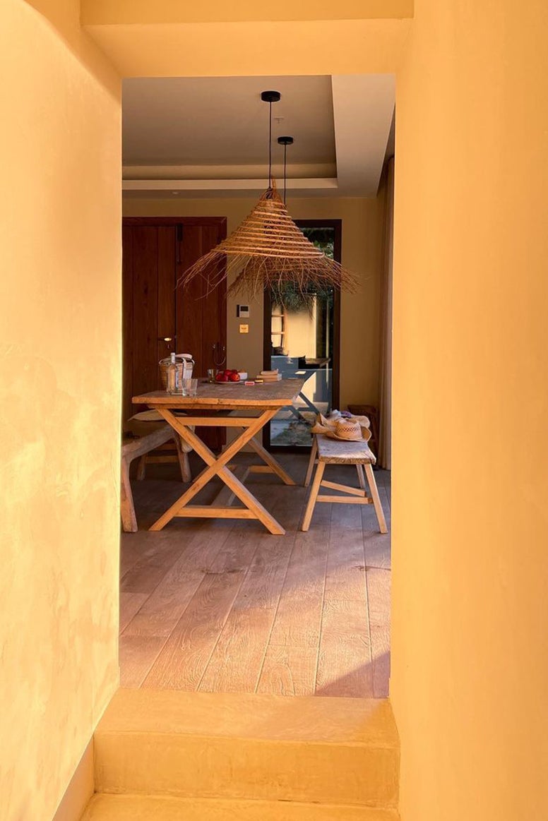 photo taken in the hallway showing the dining area in the background, it looks like an old but luxurious villa in The Mediterranean made of yellow clay or stone 